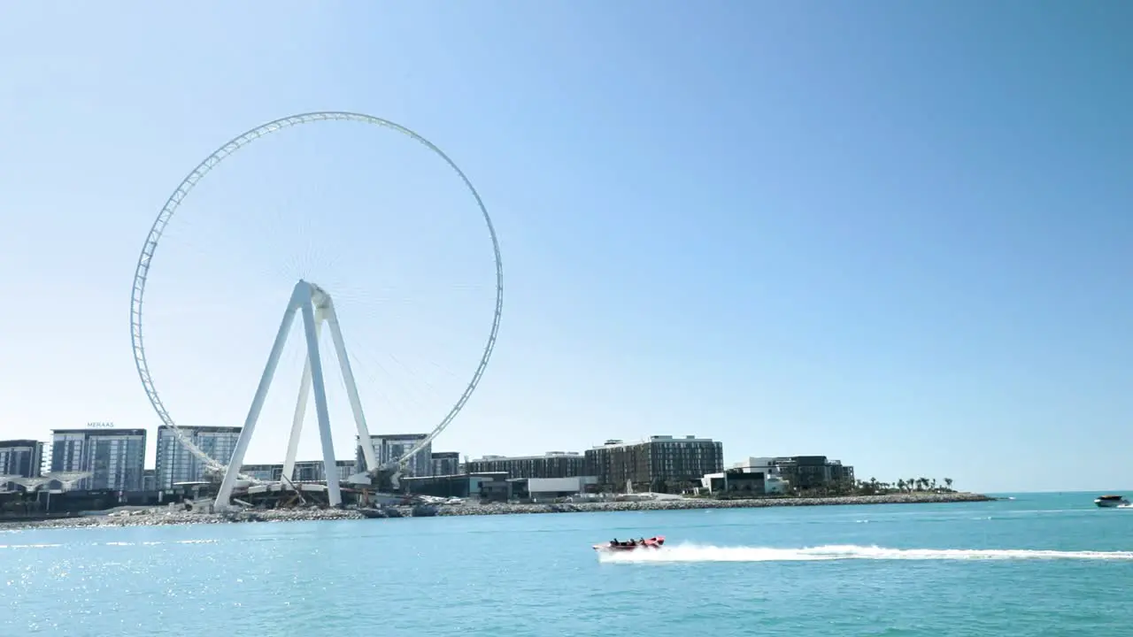 Boat Passing By Dubai Marina And Ferris Wheel In Slow Motion