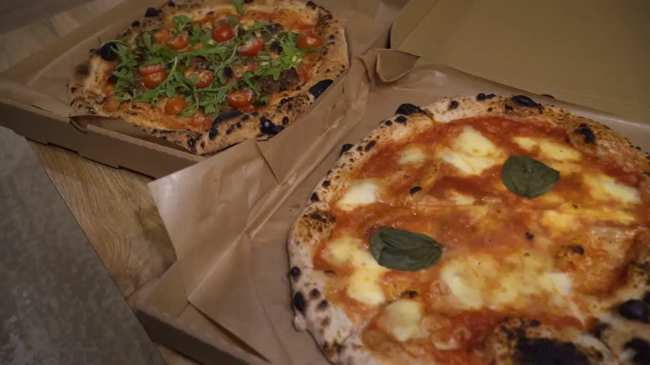 sliding shot of delicious Italian pizzas delivered in boxes on the table