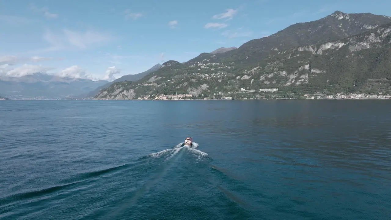 4K Aerial Following medium shot behind a classic boat in Lake Como Italy