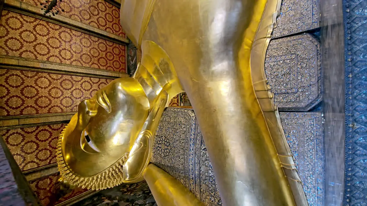 Vertical of Orbital shot taken from below of a statue of a reclining Buddha in a temple in Bangkok Thailand