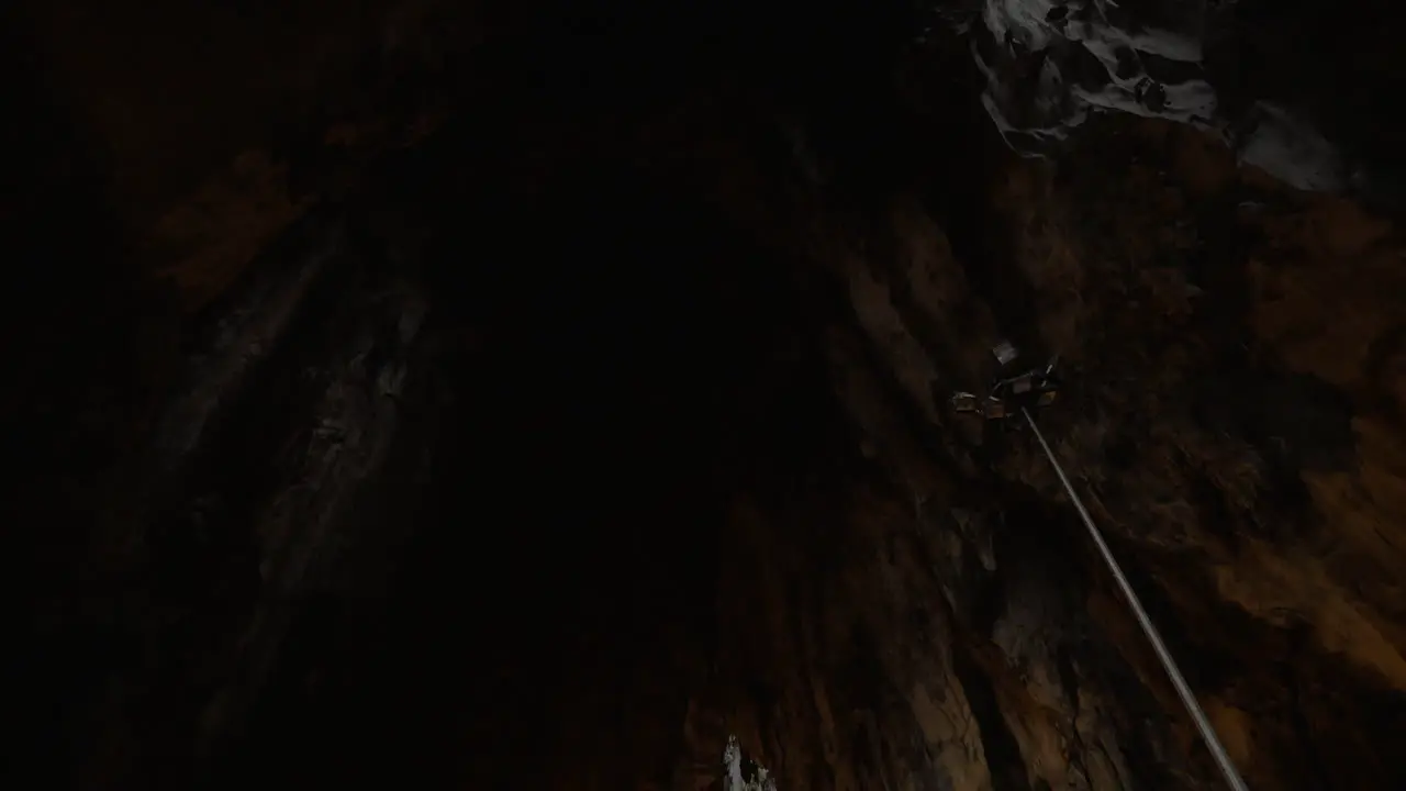 In Batu Caves seen cave with stalactite and walking tourists photographing on mobile phone landmark