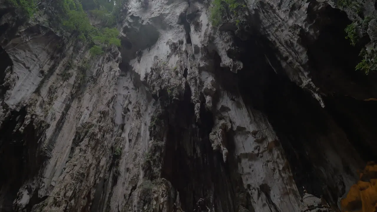 In Batu Caves seen cave with stalactite and walking tourists near the sacred temple