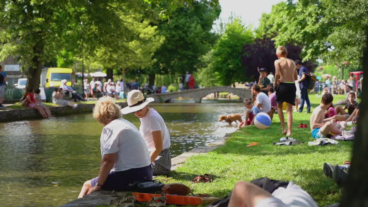 Slow motion shot of bourton-on-the-water in the busy hot summer showcasing the tourist hotspot of the cotswolds