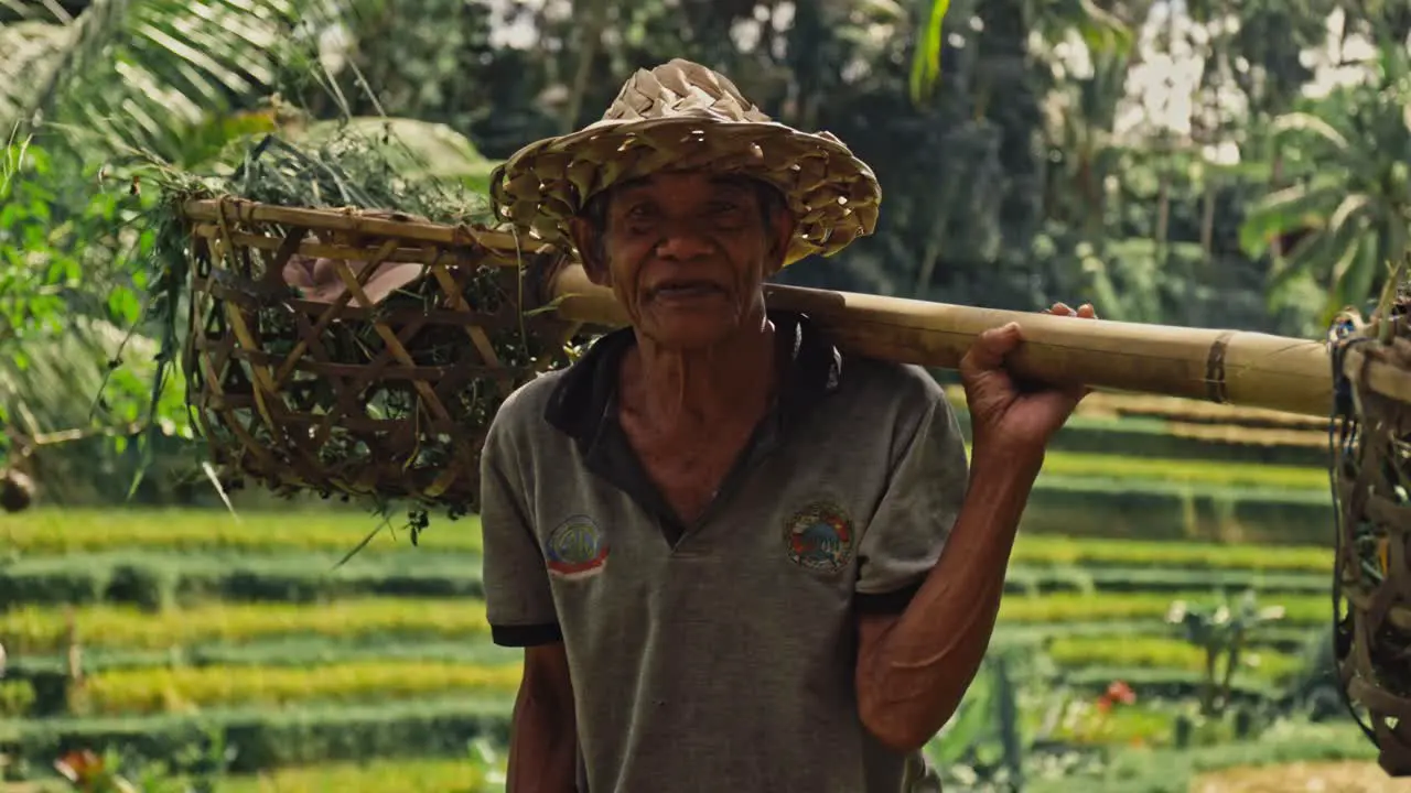 A close-up of an elderly happy rice farmer in a straw hat in Bali