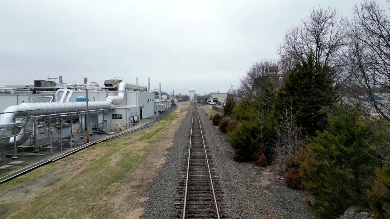 Reverse Aerial on of Train track with Factory in shot in kernsville nc