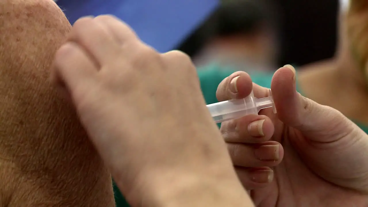 Injecting the first does of Astra Zeneca vaccine injected into a patient's arm isolated