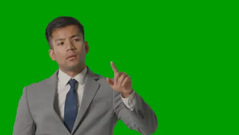 Studio Shot Of Businessman In Suit Pretending To Use AI Or VR Screen Against Green Screen 