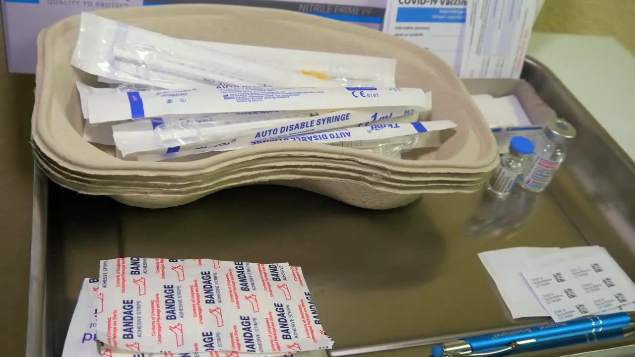 Covid 19 vaccine jars and a disposable plastic syringe medical preparations in background