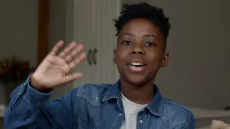 Young Boy Listening and Waving Goodbye During Video Call