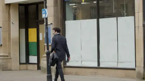 Long Shot of Man Walking Past Closed Down Shop In Oxford England