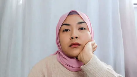 Female Student Visibly Bored Whilst Looking Directly into Camera During Remote Lecture