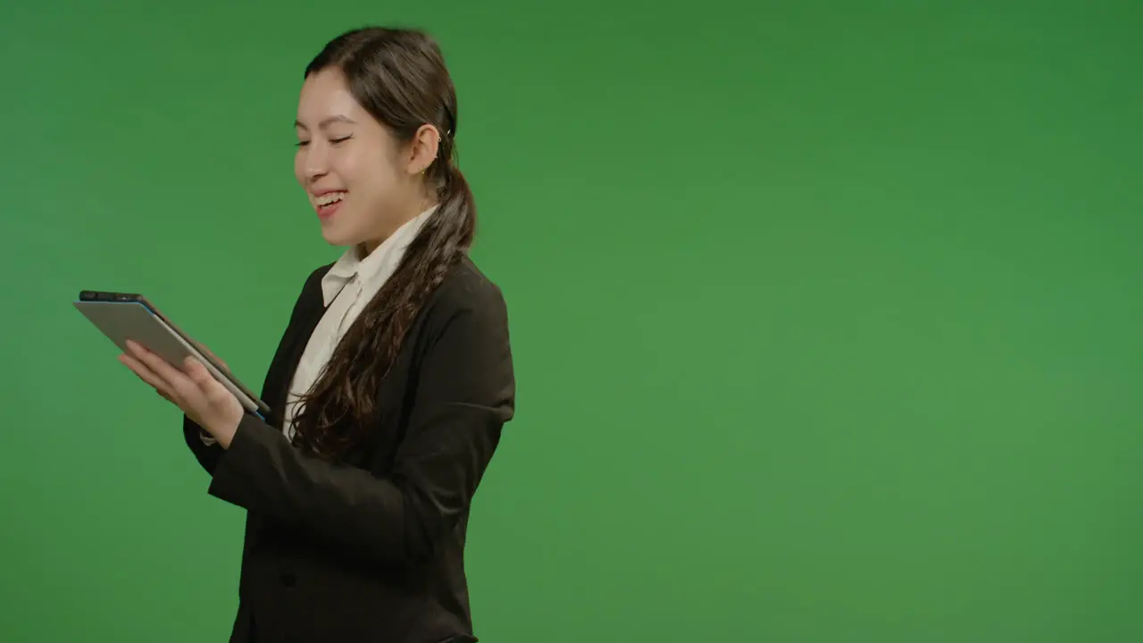 Happy Businesswoman Uses Tablet on Green Screen