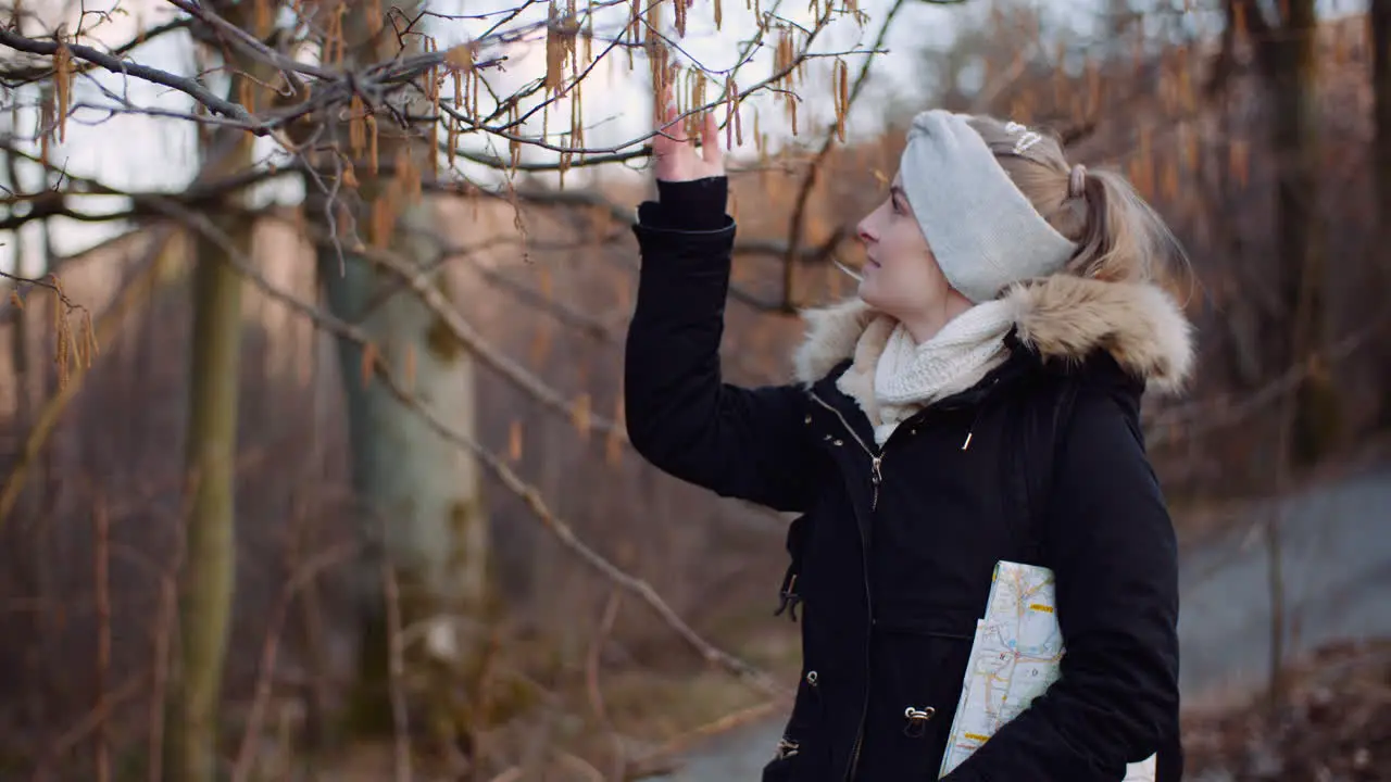 Woman Touching Tree Branch On A Walk In Park