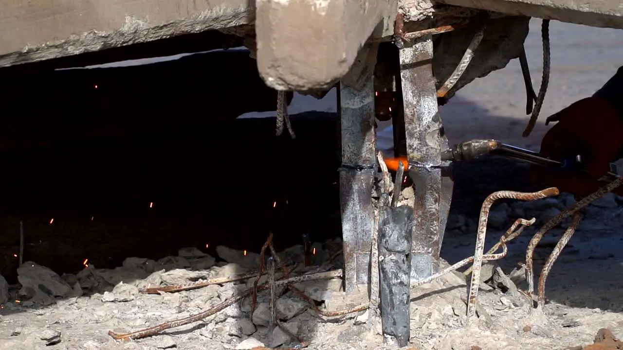 Handheld slow motion close view of sparks produced by a welder cutting a piece of steel-3