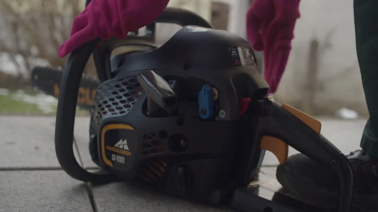 Close up of a female starting a small chainsaw