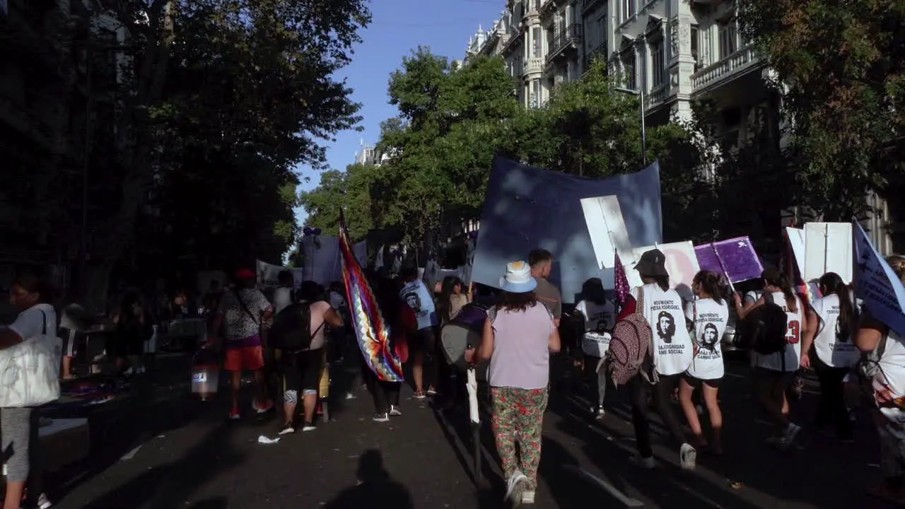 slow motion of Argentinian street protest people march with flags posters signs and che guevara prints to represent indigenous people