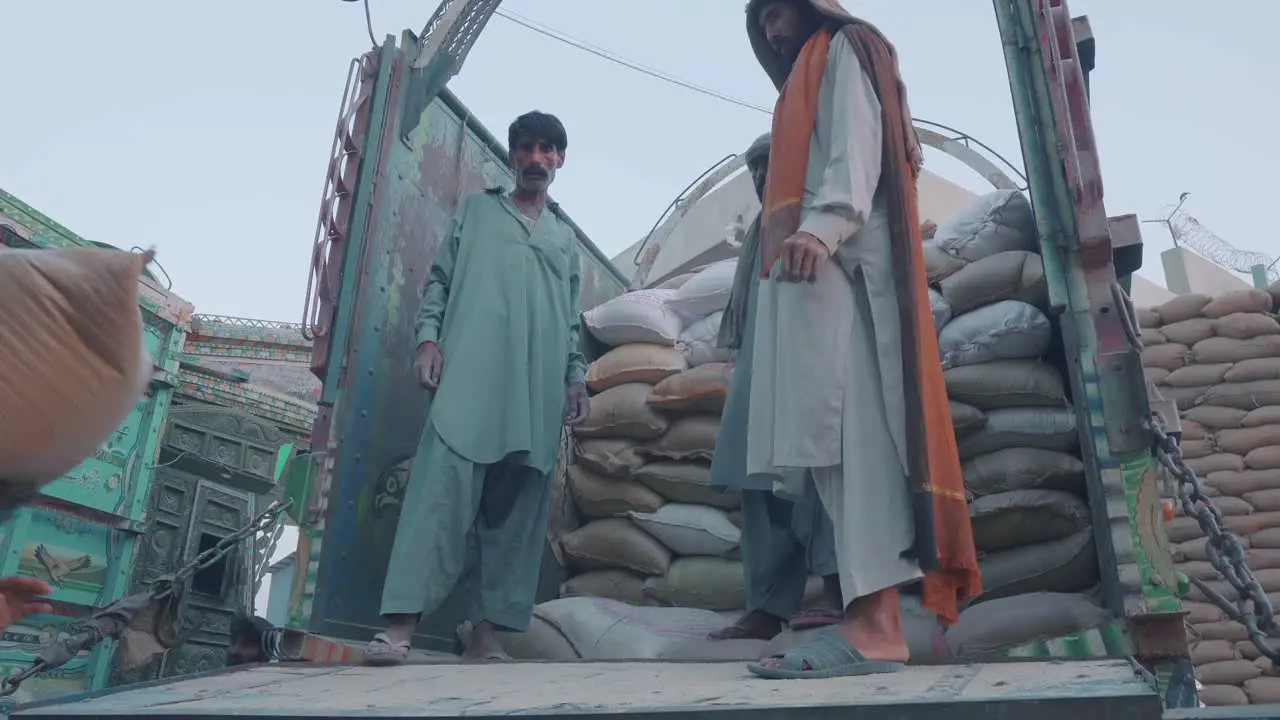 Pakistani Male Workers Lifting Sacks Of Rice Into Back Of Truck At Factory