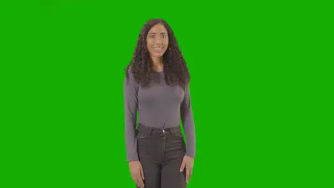 Three Quarter Length Studio Portrait Of Woman Against Green Screen Smiling At Camera