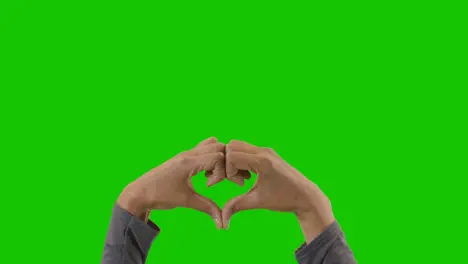 Studio Close Up Shot Of Woman Making Heart Shape Symbol For Love Against Green Screen 1