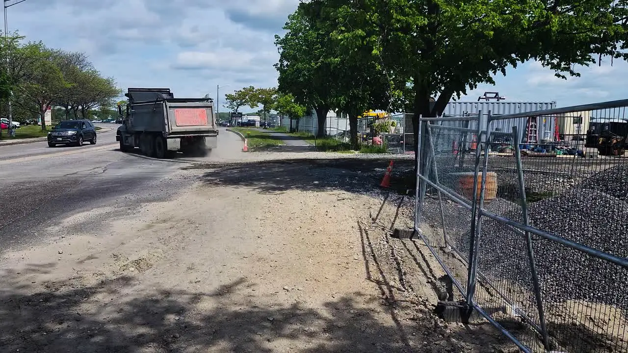 A water truck and a dump truck leave a construction site in Portland Maine