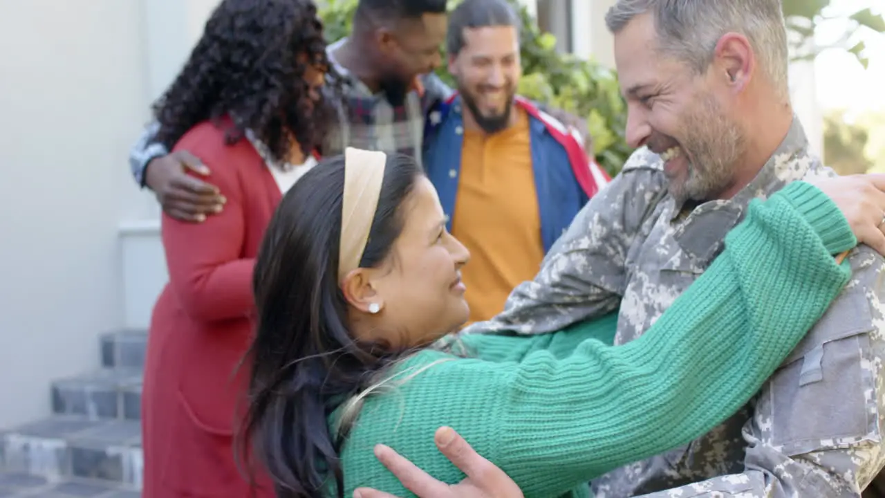 Happy diverse friends with flags welcoming home male soldier friend