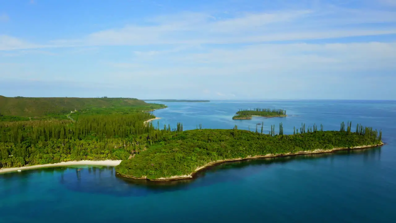 Drone shot moving forward toward a tropical coast with some little islands and beaches during a beautiful day