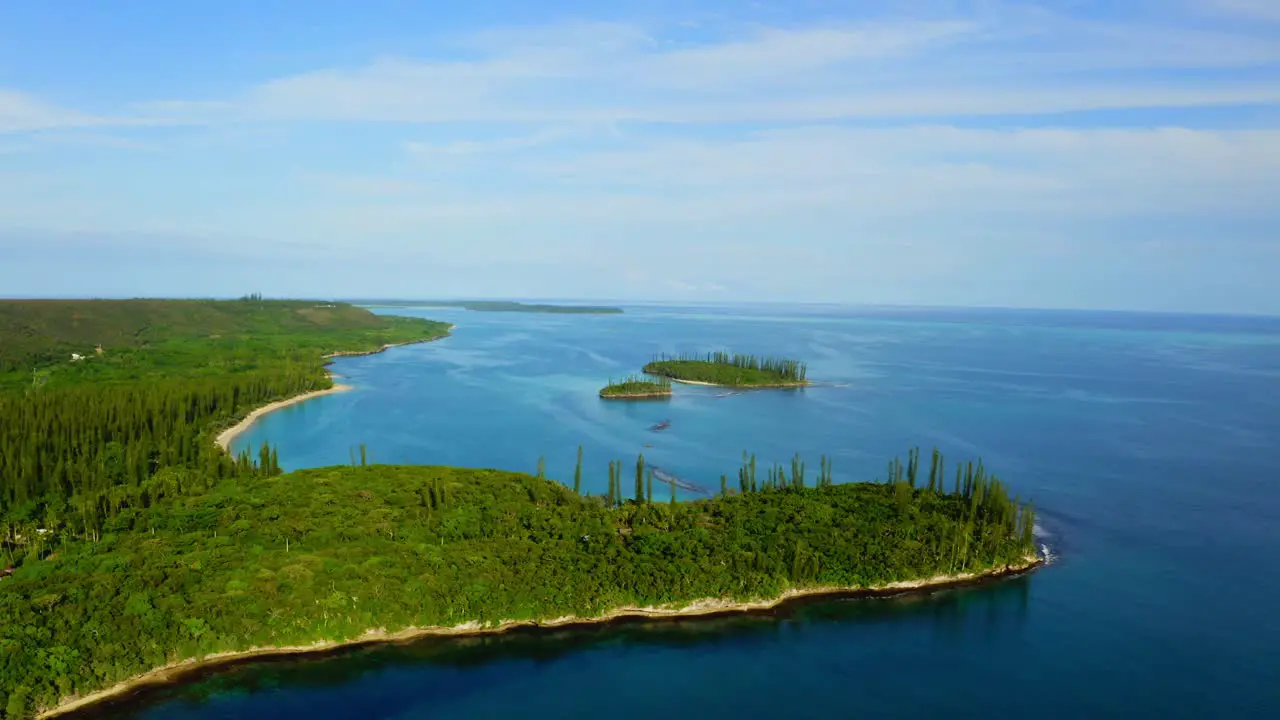 Drone shot traveling in front of a tropical coast with some little islands and beaches during a beautiful day