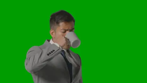 Studio Shot Of Businessman In Suit Holding Cup Of Hot Drink Against Green Screen 2