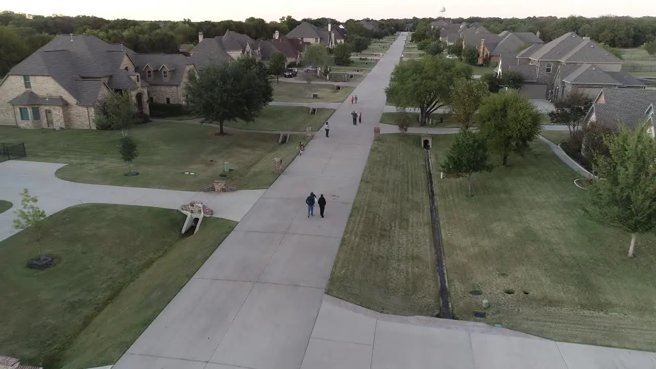 This is an aerial video of kids trick or treating on Halloween night in a neighborhood in Double Oak Texas