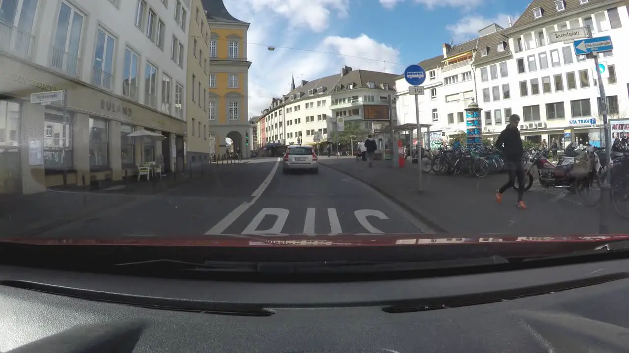 View from the dashboard of a car driving around a city of Germany