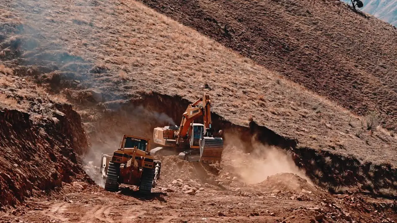 Road construction on top of the mountain bulldozer and tracked excavator cutting the rocky soil