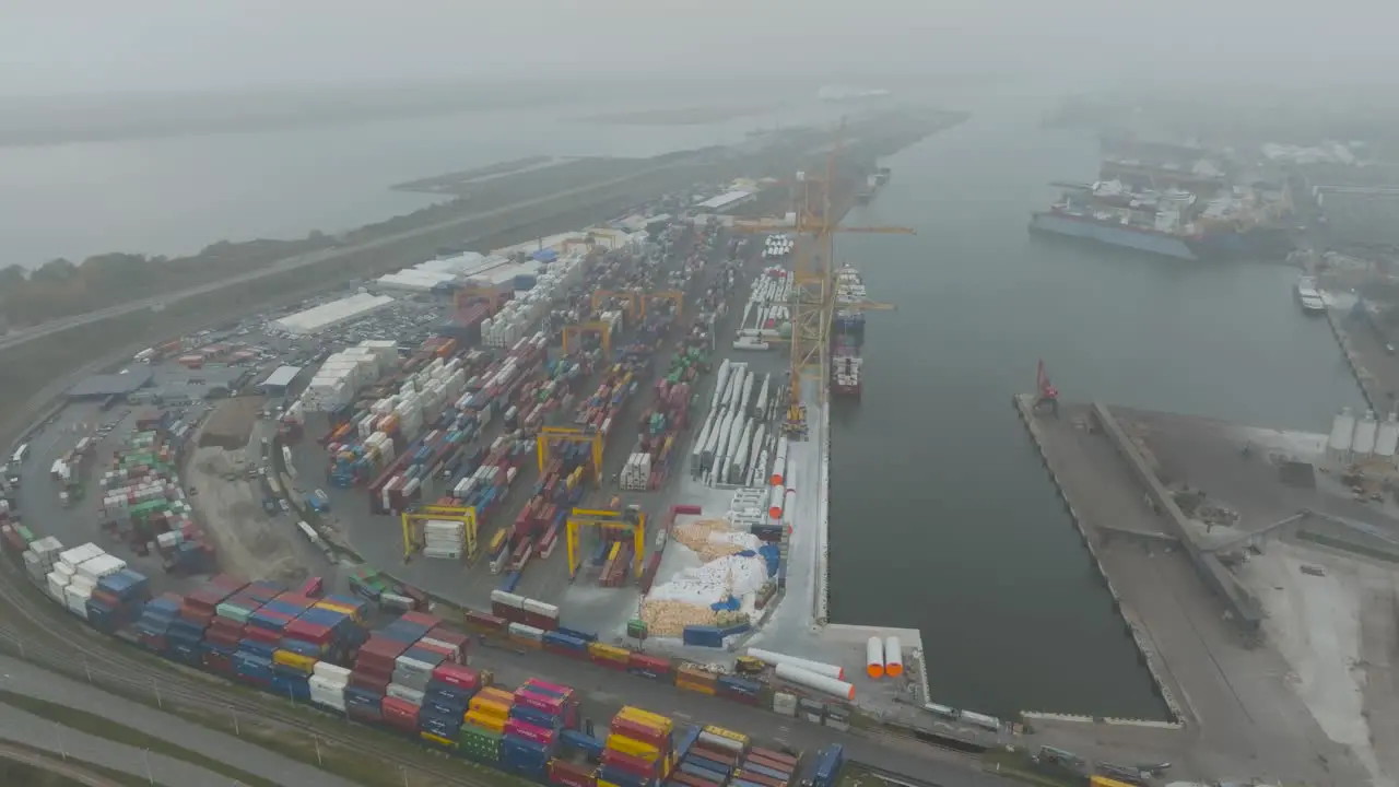 Aerial view of the port area's container terminal metal containers with cargo and ships moored at the quays in the early and dark morning in Klaipeda port