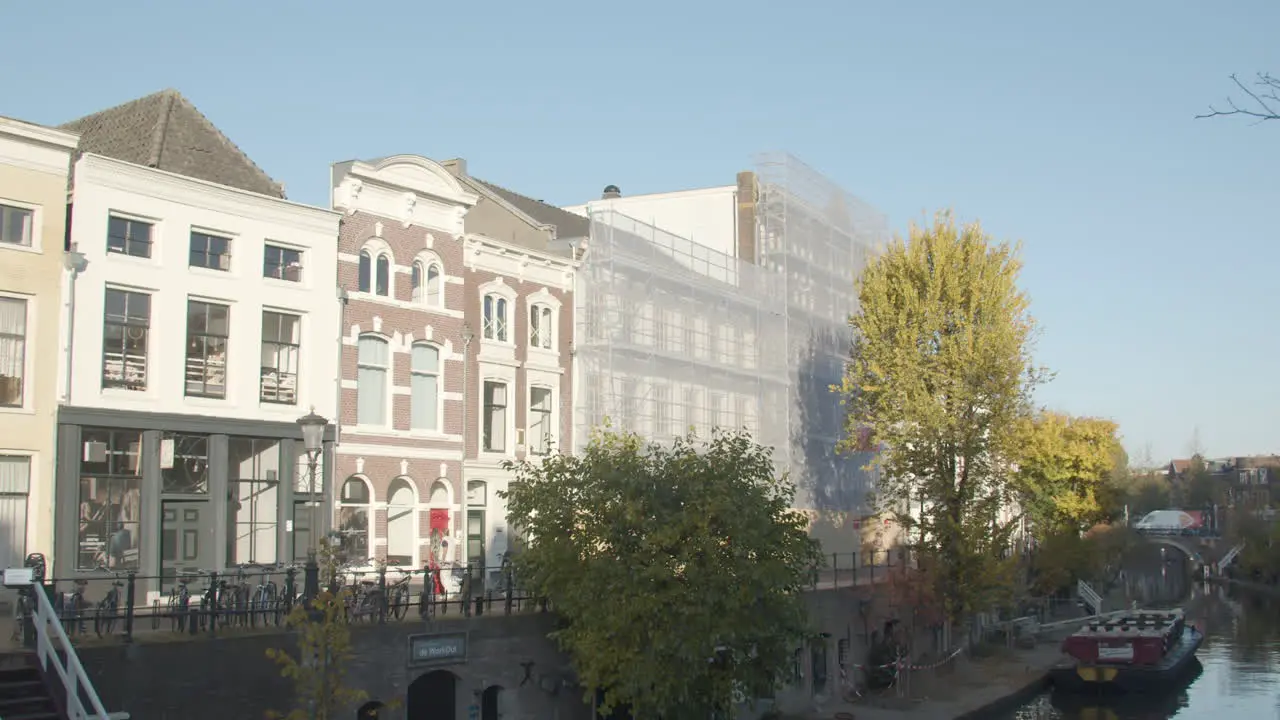 Woman cycling past beautiful old buildings near canal in Utrecht the Netherlands