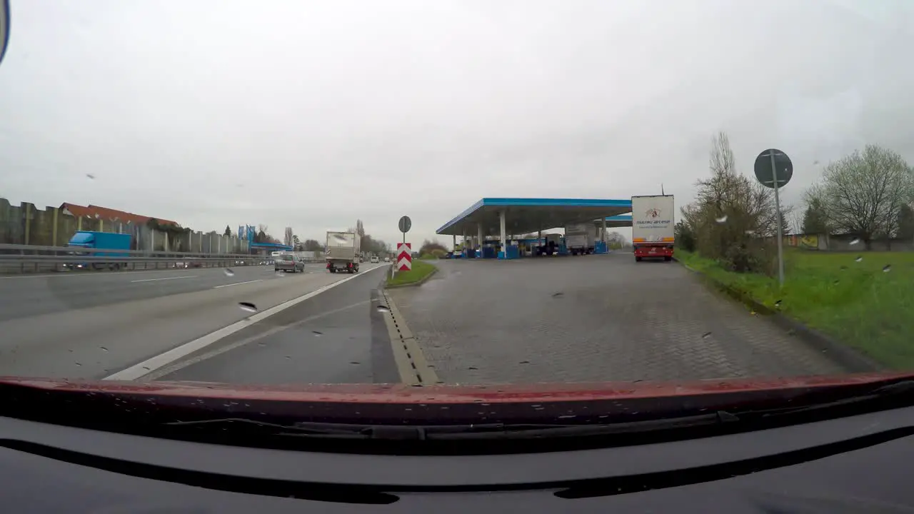 Car driving into a fuel station in a highway in Germany