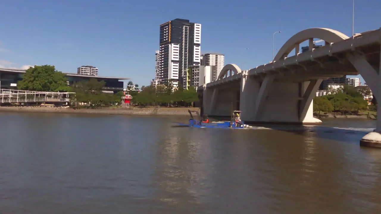 Small barge conveys Loader and crew along Brisbane River