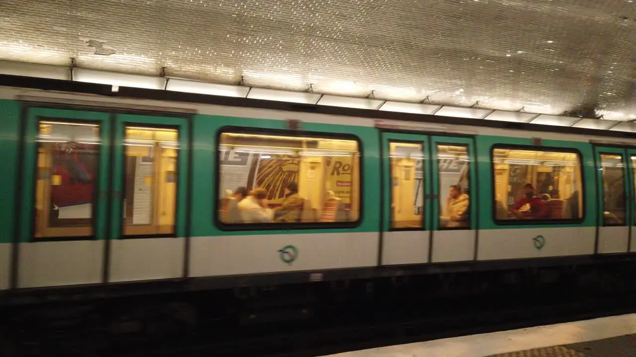 A Metro Train Leaves with People at the Metro Hoche Underground Station in Paris