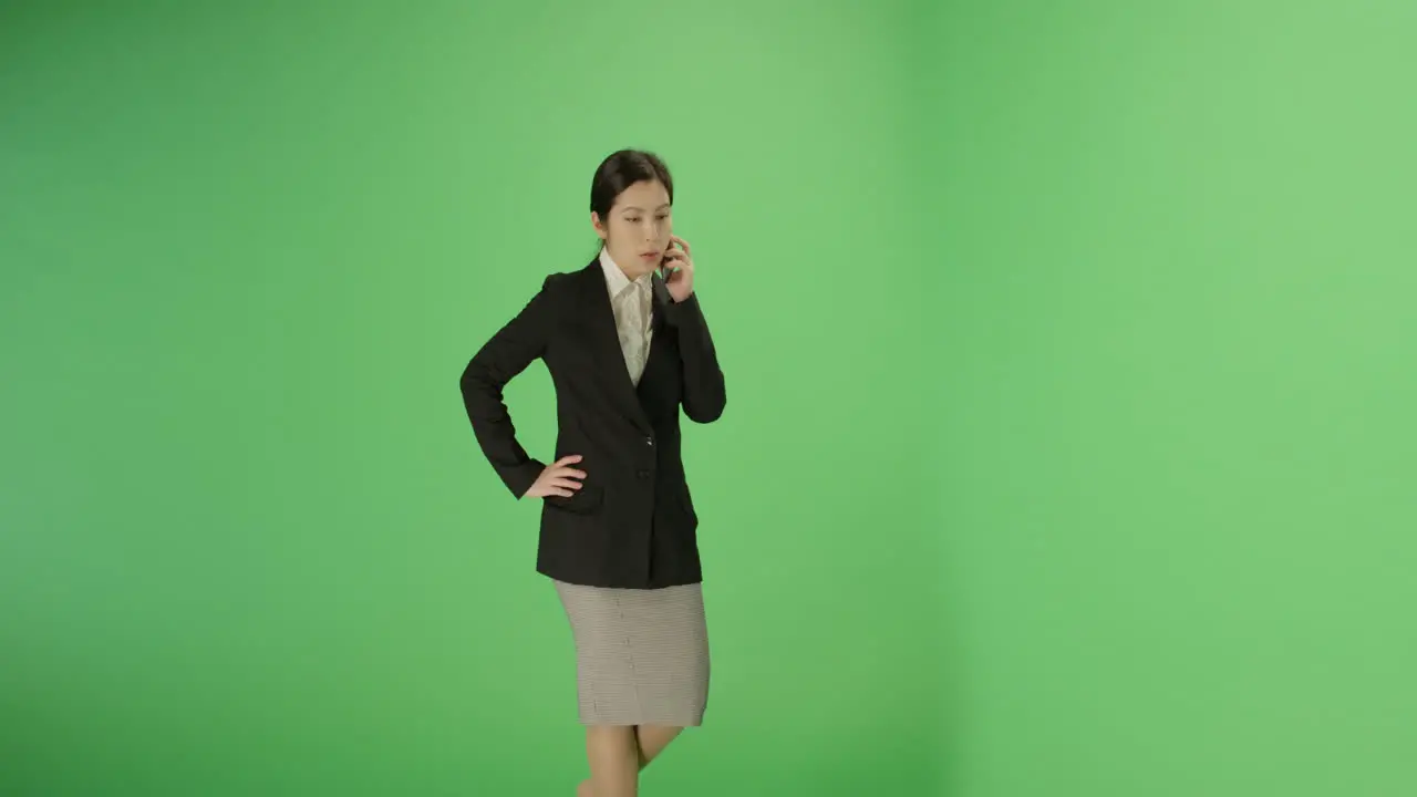 Serious Businesswoman talks on phone with green screen