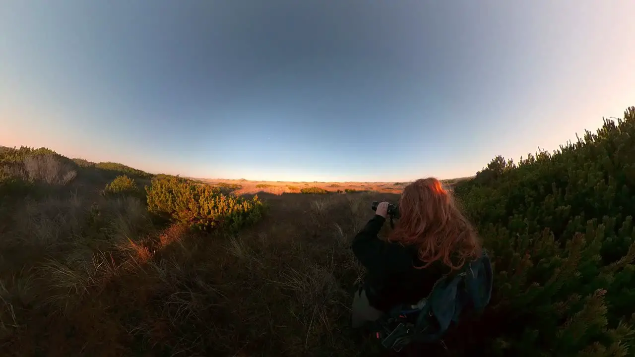 A red-haired man takes pictures of songbirds on Bandon Beach