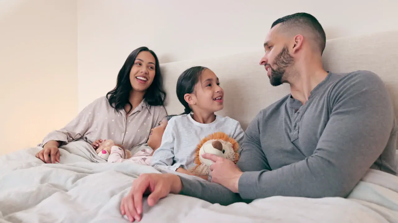 Parents children and teddy in bed