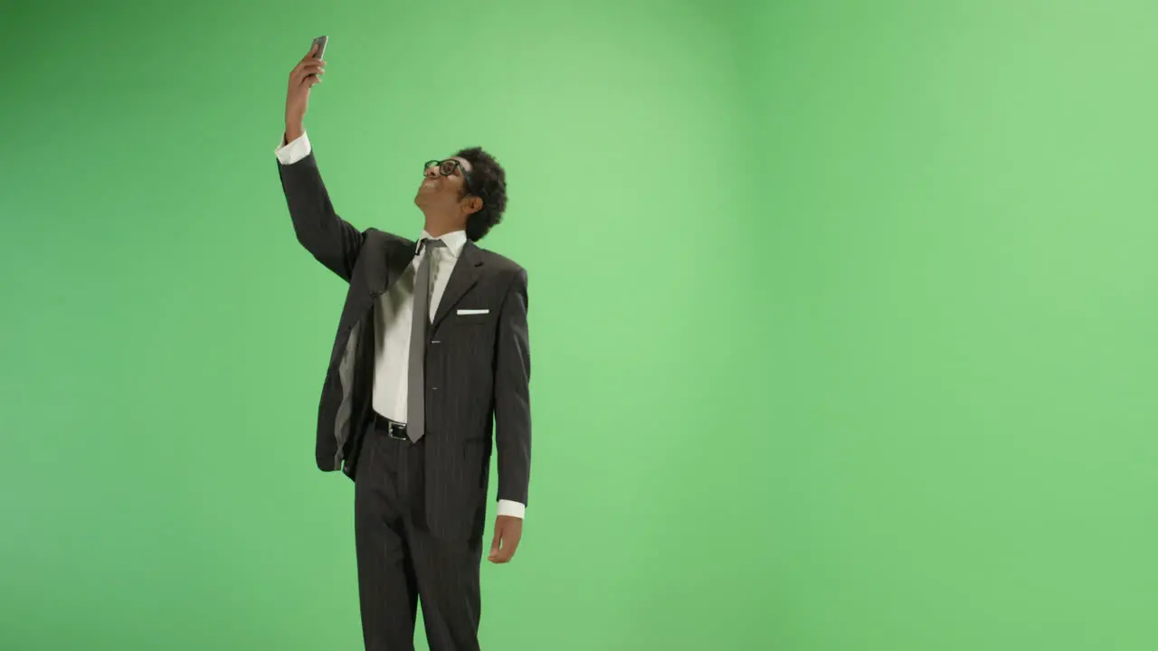 Businessman finding phone signal on green screen