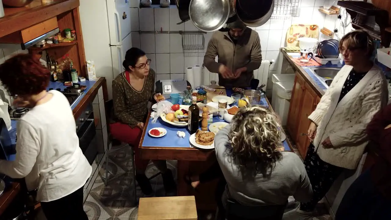 A time lapse of a group of friends having breakfast in a not very big kitchen in a rural house