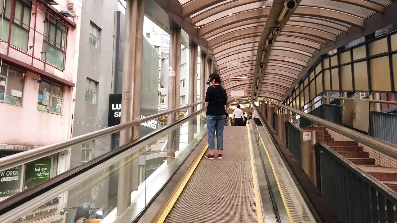 Corona Virus Pandemic Local Commuters using an escalator in downtown Hong Kong wearing protective face masks