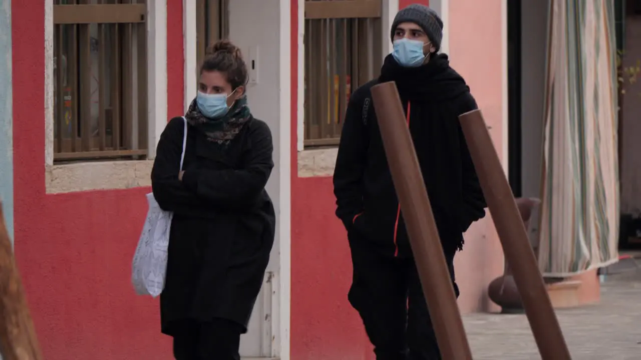 Walking Young Couple In Blue Protective Masks In Burano Island Venice