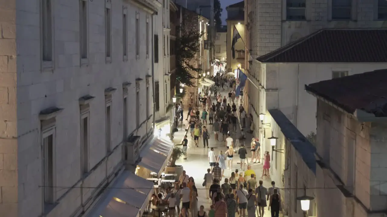 Nightlife on the street in old town Zadar where tourists walk on whitewashed stone to enjoy history in the cool of the night