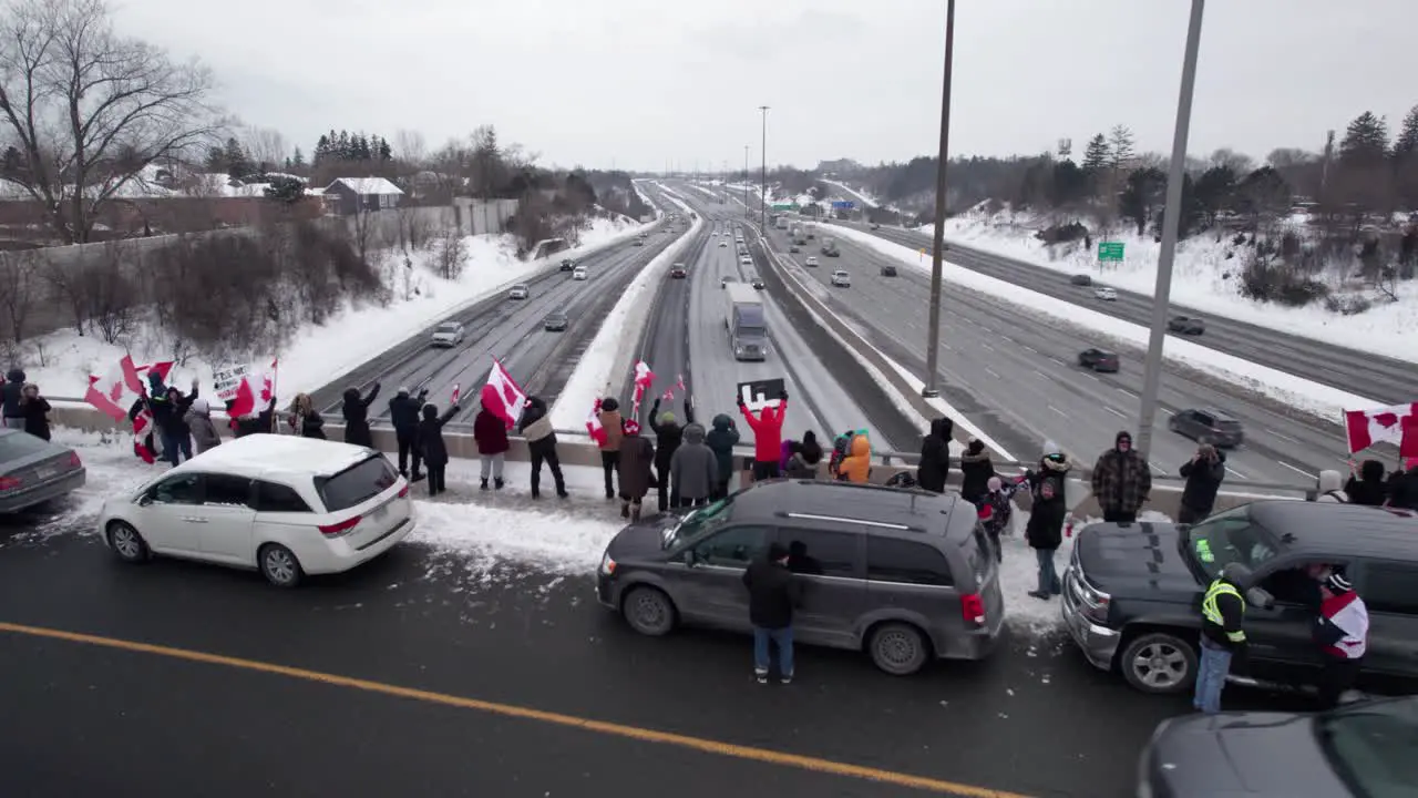 Freedom Rally Protestors standing on the edge of Busy Highway Bridge