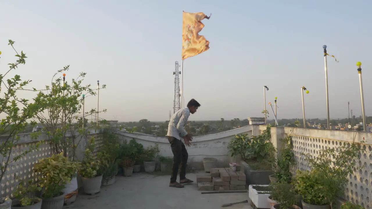 Young man at roof under religious and cultural Hindu flag