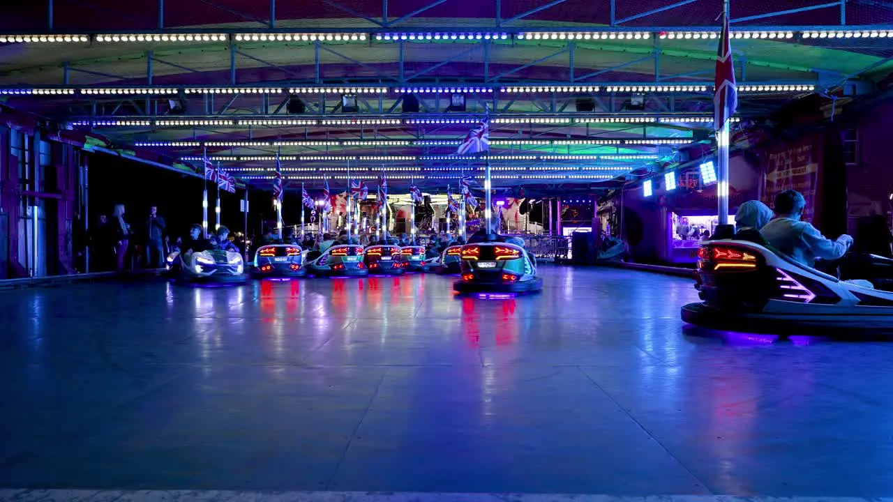 Extravagantly lit dodgem cars circle the floor on a ride at Stokesley Fair September 2022