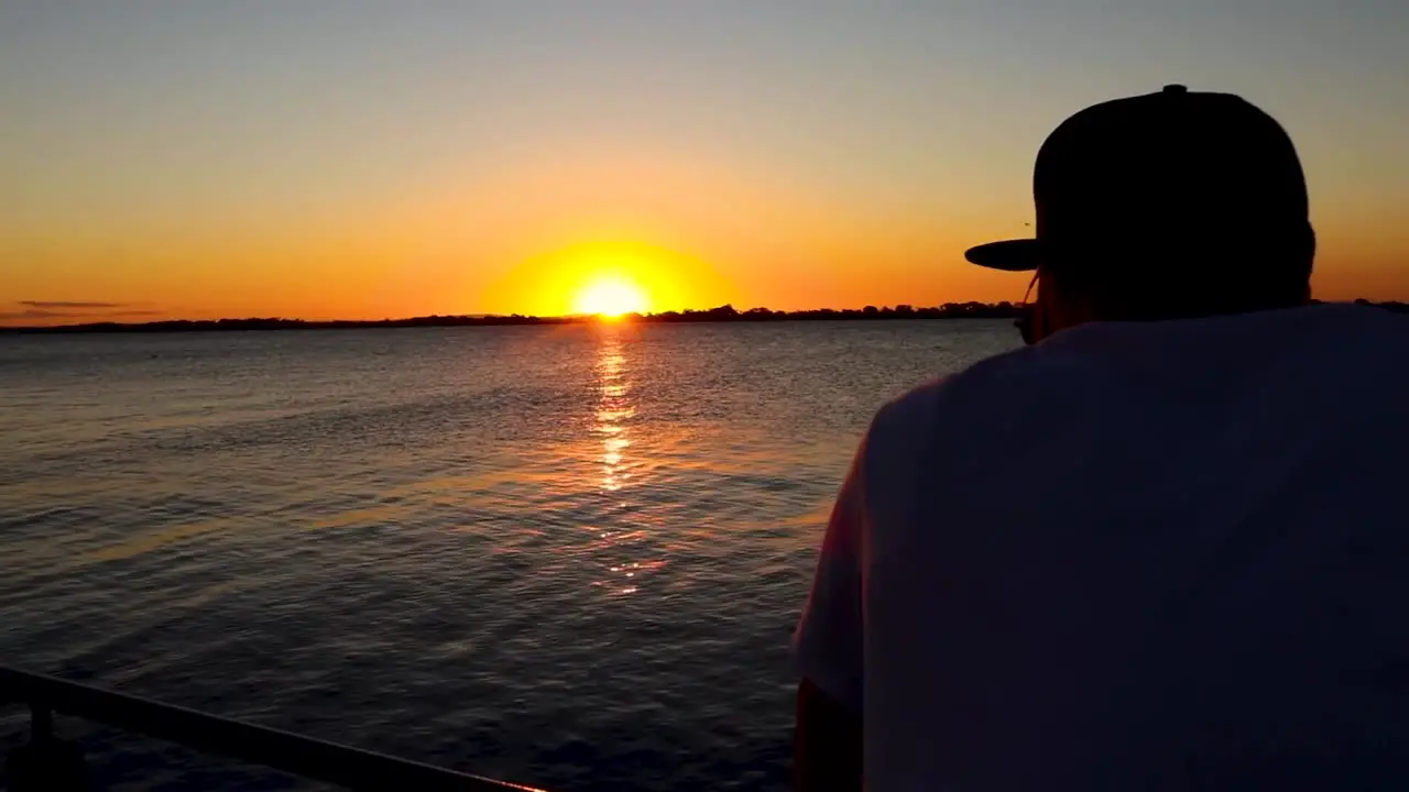 Tracking Shot of Man Looking at Sunset River on a Deck