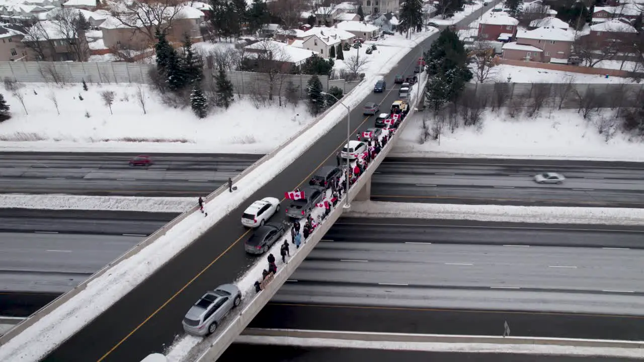 Aerial Orbit of Freedom Rally Protestors standing along the edge of 401 Highway Bridge