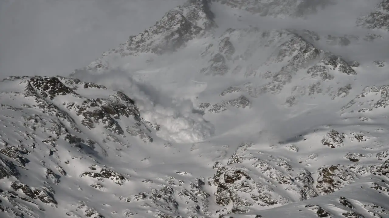 View of an avalanche rolling down a snowy mountain in the Swiss alps in Saas Fee raised snow fog science phenomenon